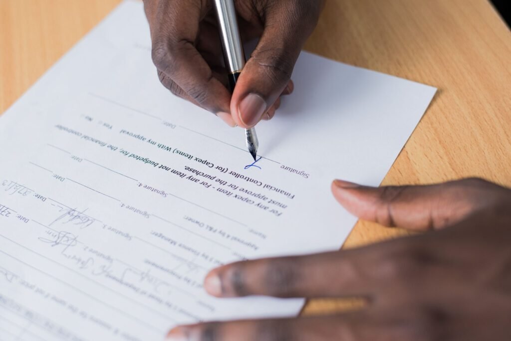 Professionnel africain en costume dans un bureau moderne à Lubumbashi, signant une traduction assermentée avec cachet officiel