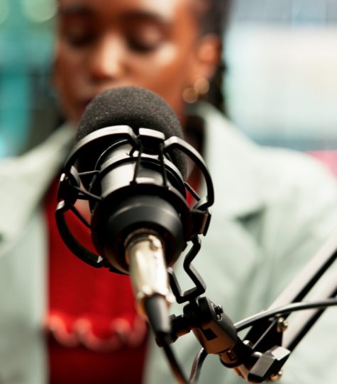 Mic, black woman and speaking in studio for broadcast, podcast recording and blur of talk show. Audio equipment, speaker and live streaming for radio channel, news announcement and entertainment host